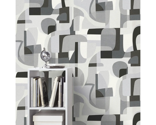 Behang met abstract vormenpatroon in verschillende grijstinten op de achtergrond, rek met decoratieve artikelen op de voorgrond.