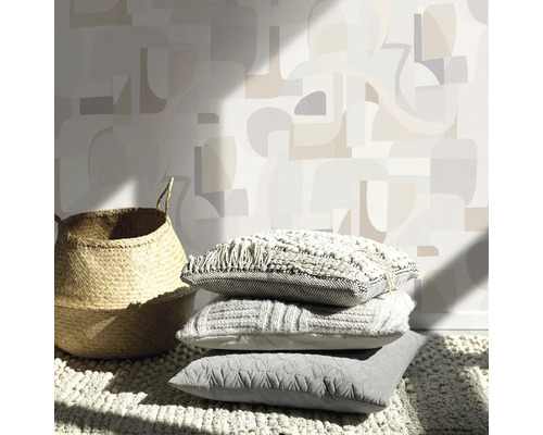 Decoratieve scène met mand, stapel kussens en gemustereerd behang voor een gezellige sfeer