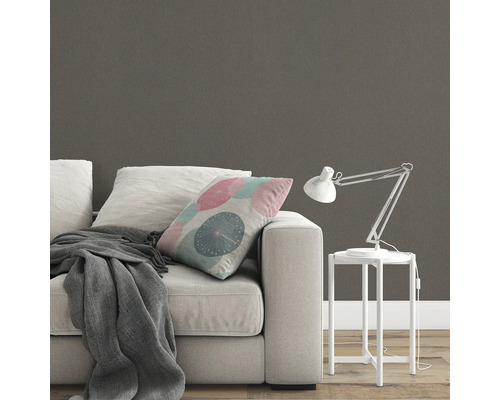 Scene met bank, kussen, deken, bureaulamp en behang met patroon