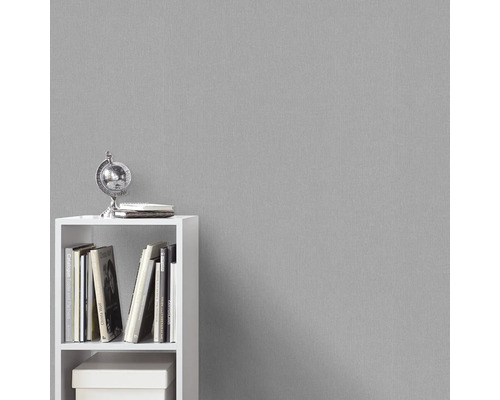 Grijze structuurbehang op de achtergrond met witte boekenplank en decoratie