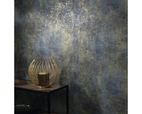 Close-up van een gestructureerd behang met een abstract patroon in gedempte kleuren en een gouden kandelaar