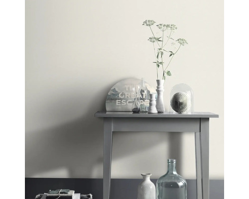 Decoratief arrangement op een grijze tafel met vaas en kamerplant.