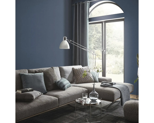 Woonkamer met grijze bank, kussens, lamp en raam