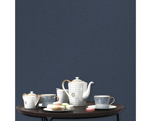 Theeservies en macarons op een tafel voor een blauwe wand