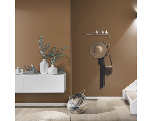 Lichte en georganiseerde hal met witte kast, decoratie, hoed en mand