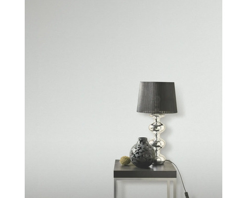 Scene met een tafellamp, een vaas en een decoratieve bol op een bijzettafel.