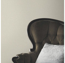 Beige wand met fauteuil en kussen