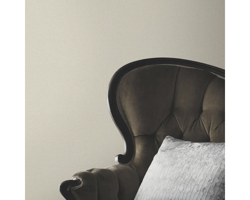 Beige wand met fauteuil en kussen