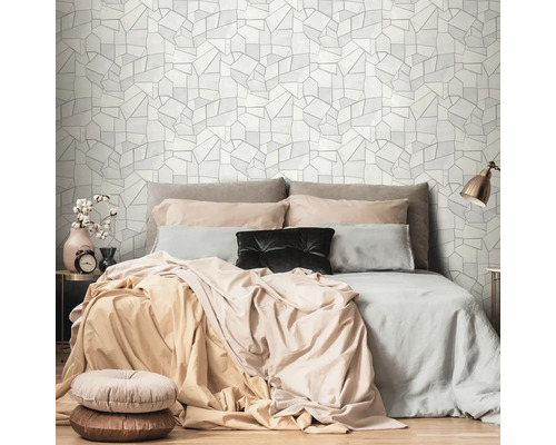 Slaapkamer met bed en geometrisch behang op de achtergrond