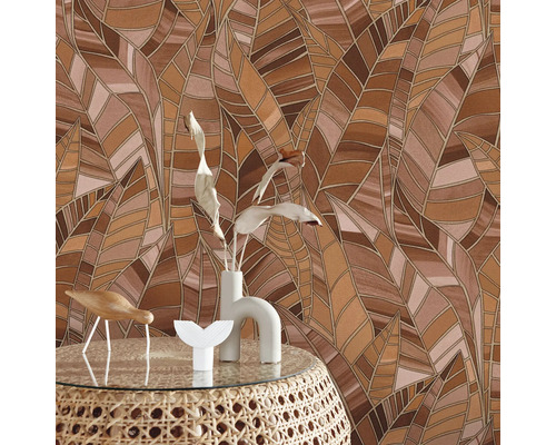 Behang met bruin bladerpatroon achter een tafel met decoratie