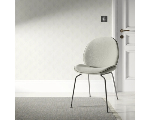 Scene met een gestoffeerde stoel met metalen poten en een vloerkleed