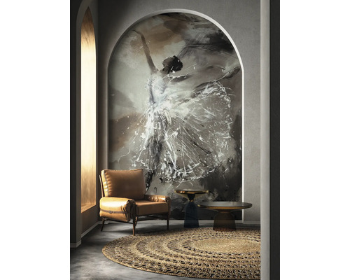 Woonkamer met fauteuil, vloerkleed en een wanddecoratie die een dansende vrouw voorstelt.