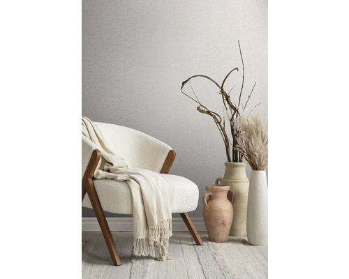 Decoratieve kamer met stoel, deken, vazen en behang met patroon.