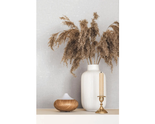 Decoratieve opstelling met een aromaverspreider, kandelaar met kaars en een vaas met siergras
