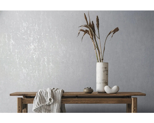 Woonkamer met patroonbehang, houten tafel en decoratieve elementen