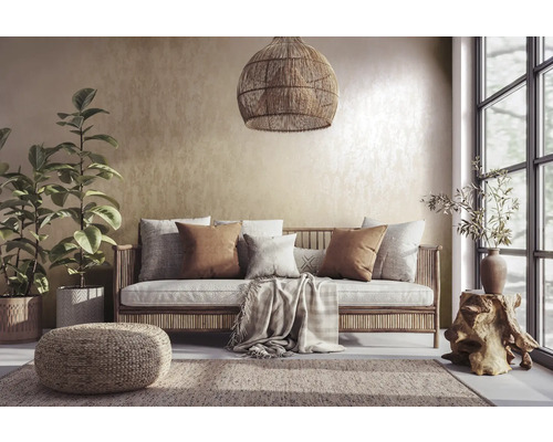Woonkamer met rotan bank, kussens, vloerkleed en kamerplanten