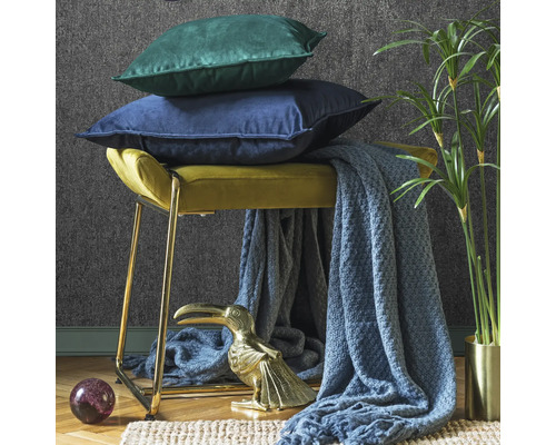 Scene met kruk, kussens, deken, decoratie en kamerplant