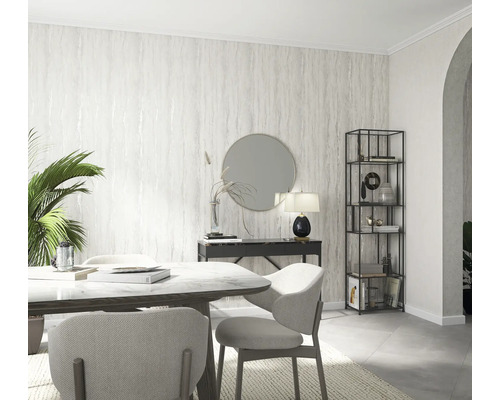 Lichte eetkamer met eettafel, stoelen, console, spiegel en boekenkast tegen een patroonbehang.