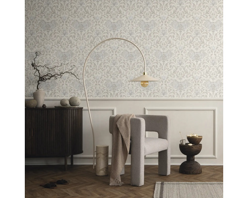Woonkamer met behang met motief, fauteuil en staande lamp
