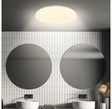 Badkamer met ronde spiegels, wastafels en ronde plafondlamp