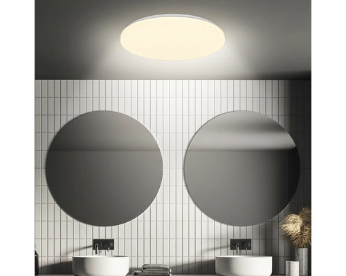 Badkamer met ronde spiegels, wastafels en ronde plafondlamp