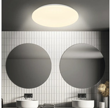Badkamer met ronde spiegels, wastafels en ronde plafondlamp