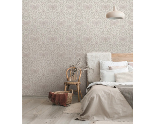 Slaapkamer met behang met motief, bed en rieten stoel