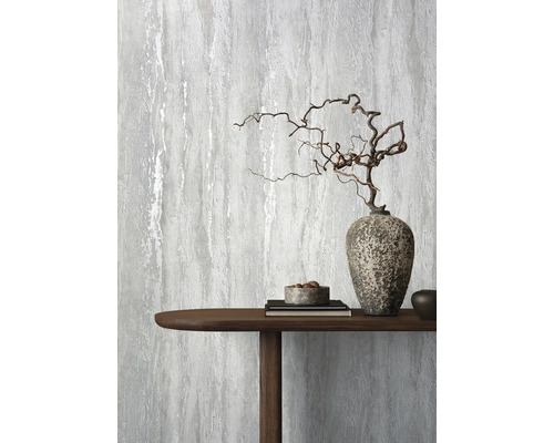 Decoratief grijs behang met een abstract ontwerp naast een houten tafel met decoraties.