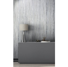 Decoratieve kamer met behang in marmerlook, tafellamp en decoratieve objecten op een dressoir