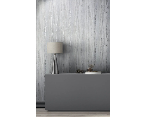 Decoratieve kamer met behang in marmerlook, tafellamp en decoratieve objecten op een dressoir