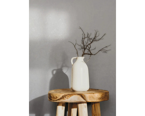Decoratieve takken in een witte vaas op een houten kruk