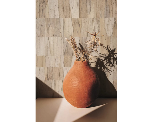 Decoratieve vaas met droogbloemen op een tafel voor een gestructureerde wand
