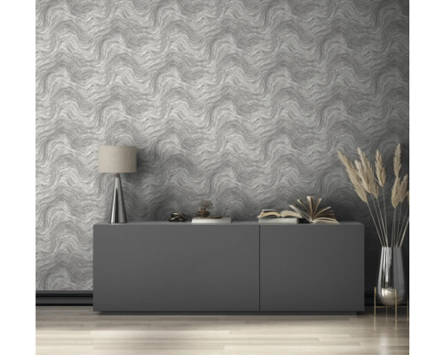 Woonkamer met patroonbehang, dressoir, lamp en decoraties