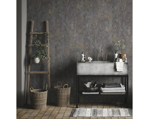Badkamer met grijze wandtegels in steenlook, betonnen wastafel, houten ladder, manden en gestreept vloerkleed
