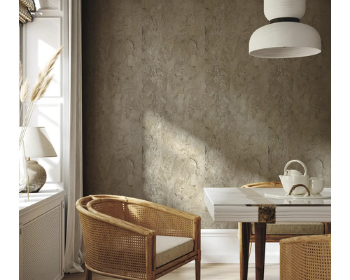 Woonkamer met wandtegels in steenlook, rotan stoelen en eettafel met theeservies.
