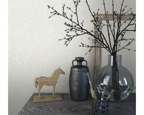 Decoratieve opstelling met vaas, takken, paardenbeeld en penselen op een tafel.