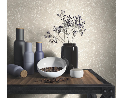 Decoratieve scène met vazen, schaal en takken op een tafel voor een wandbehang.