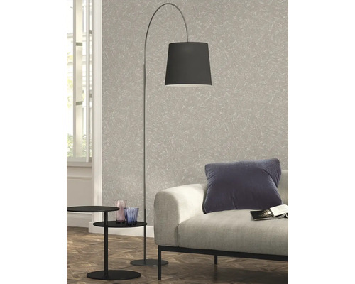 Vloerlamp met lampenkap naast een bank en een bijzettafel