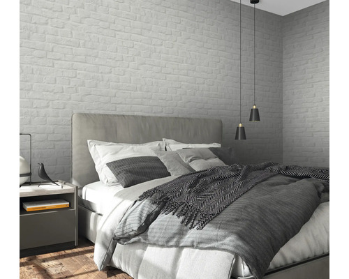 Slaapkamer met bed, nachtkastje en wandbehang in metselwerkdesign.
