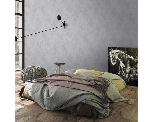 Slaapkamer met bed, nachtkastje, kruk en wandlamp voor grijze muur