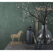 Decoratieve scène met houten paard, vaas, takken en fotolijst op een tafel.