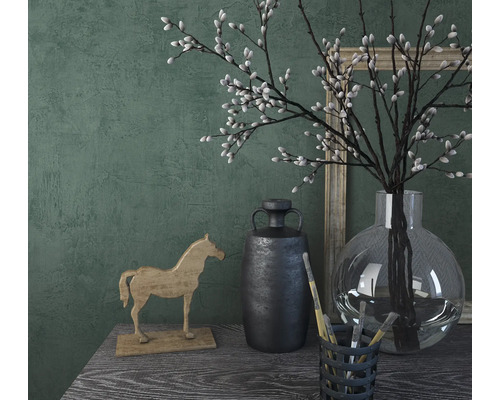 Decoratieve scène met houten paard, vaas, takken en fotolijst op een tafel.