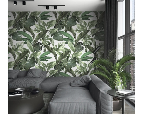 Woonkamer met bank, tafel, kamerplant en wandbehang met bladerenprint