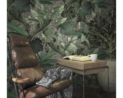 Woonkamerscène met stoel, tafel, boek, kop en planten voor een behang met bladerpatroon