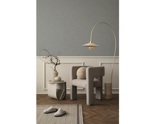 Woonkamer met fauteuil, booglamp, bijzettafel, decoratie en tapijt voor een gezellige sfeer