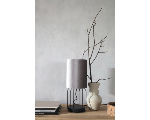 Decoratieve tafellamp met stoffen kap en metalen frame op een tafel