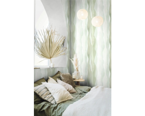 Slaapkamer met bed, kussens, nachtkastje, decoratie en behang met patroon.