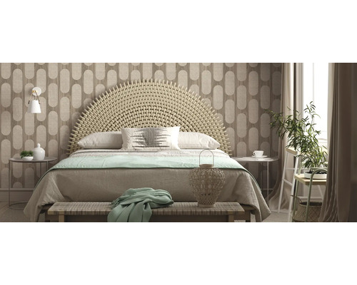 Lichte slaapkamer met gevlochten hoofdeinde, behang met patroon en decoratieve elementen.