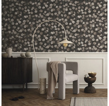 Woonkamer met behang met patroon, fauteuil, staande lamp en dressoir