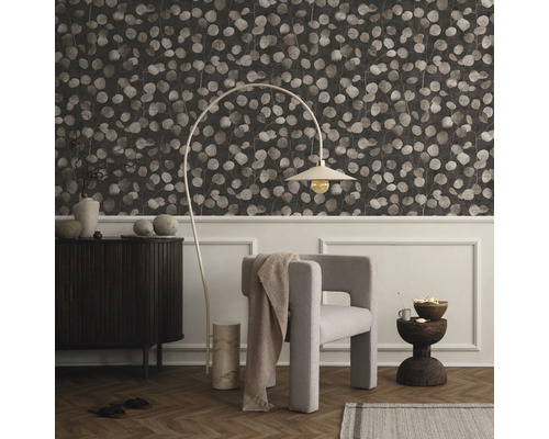 Woonkamer met behang met patroon, fauteuil, staande lamp en dressoir